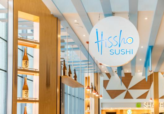 A fancy sign hanging that reads "Hissho Sushi"