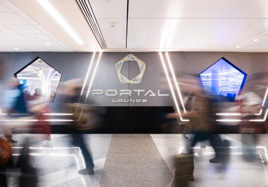 Hustle and bustle of passengers walking by portal lounge. 