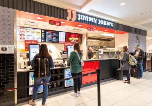 A picture of a people ordering their sandwiches.
