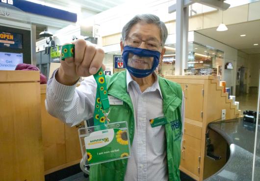 A volunteer shows how easy it is to get a lanyard