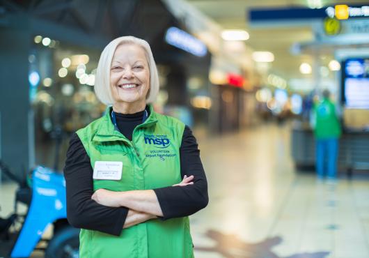 A smiling Airport Foundation Volunteer in the Airport Mall