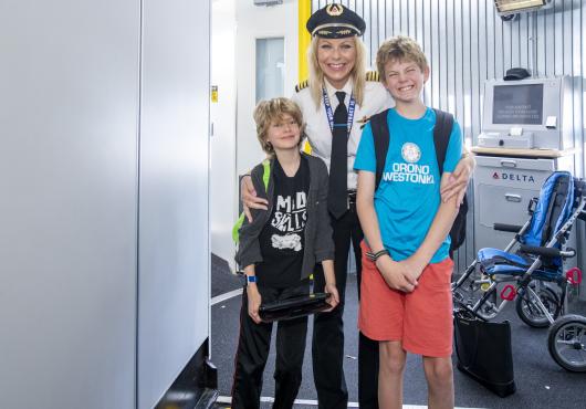 A pilot meets with two youths before their mock flight.