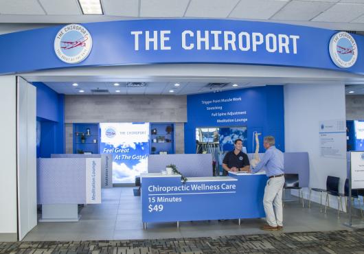 Exterior of The Chiroport with a blue reception desk and blue signage.