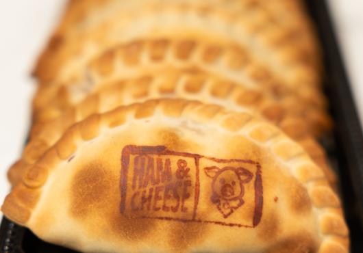 Tray of warm and delicious ham and cheese Half Moon Empanadas.
