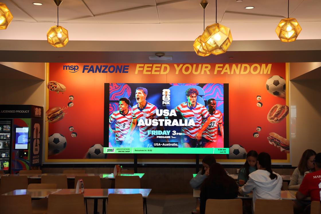 Large TV screen showing soccer matches.