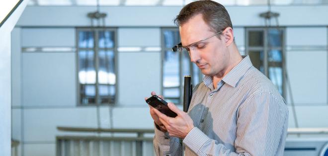 A man wearing Google Glass is talking to an Aira agent over his mobile device